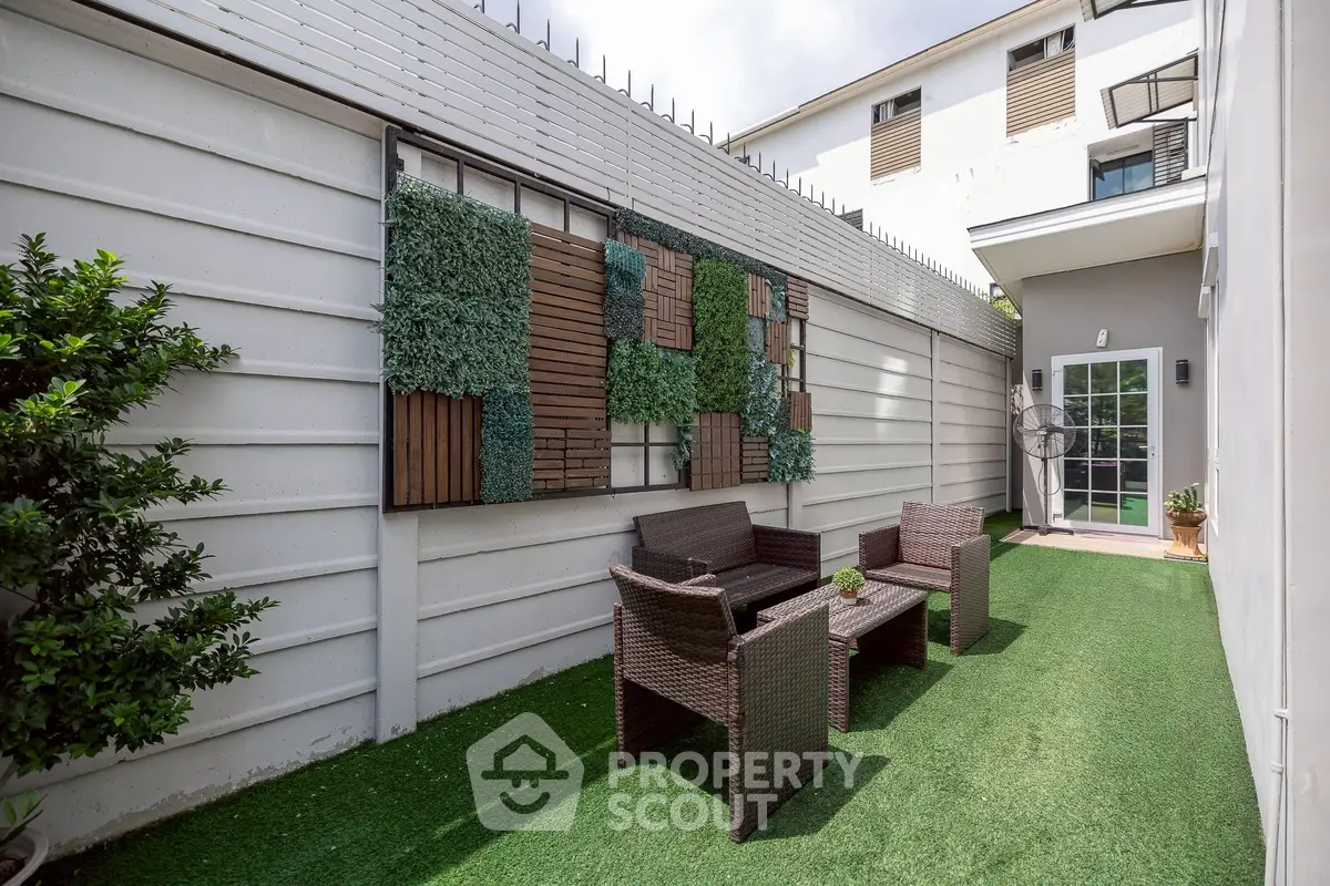 Charming outdoor patio with stylish furniture and artificial grass, perfect for relaxation and entertaining.