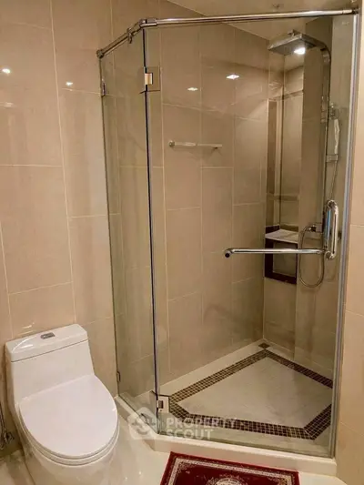 Modern bathroom with glass shower enclosure and sleek toilet design.