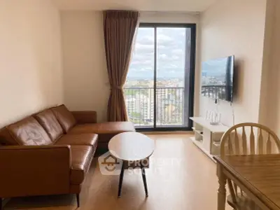 Modern living room with leather sofa and city view from large window.