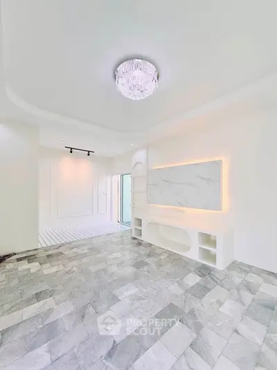 Elegant living room with marble flooring and modern lighting in a stylish apartment.