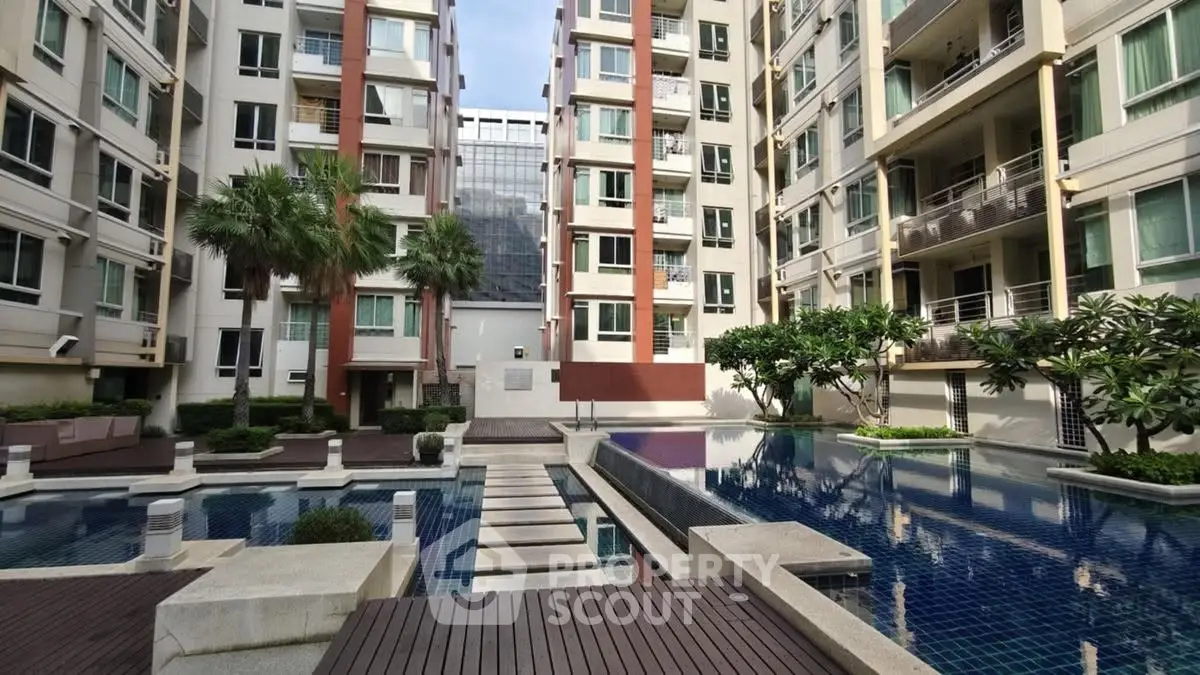 Luxurious condominium with modern pool and lush landscaping in urban setting.
