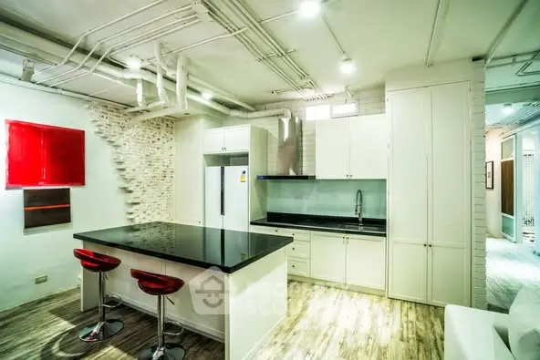 Modern kitchen with island, red accents, and sleek cabinetry