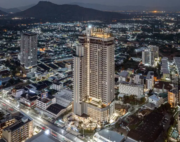 Stunning aerial view of a modern high-rise building at night with cityscape backdrop.