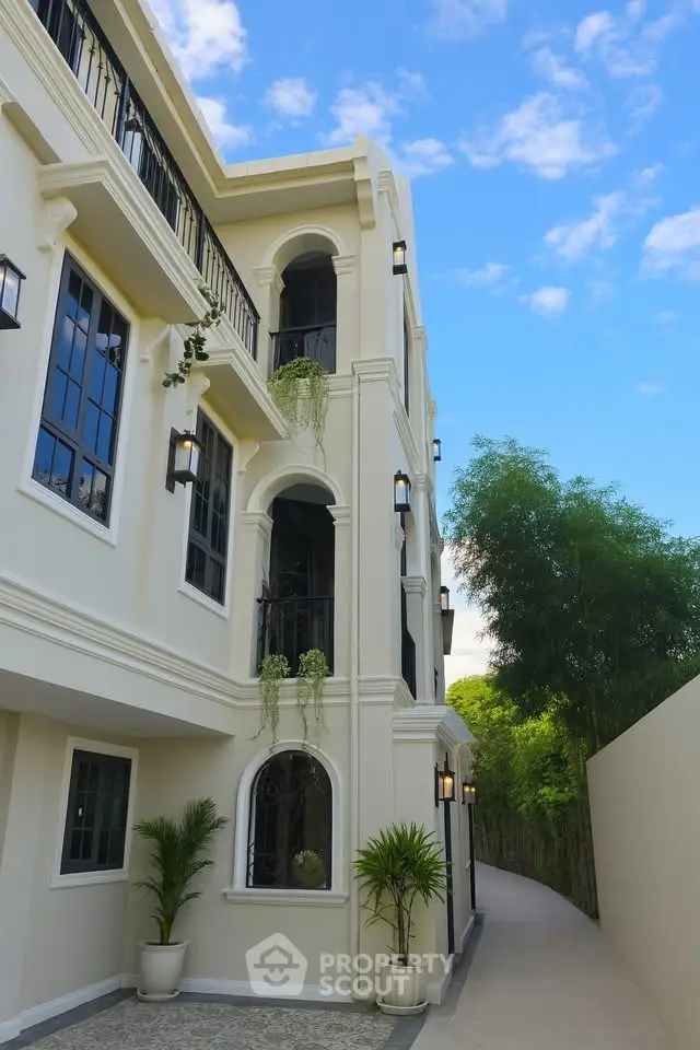 Elegant three-story building with classic architecture and lush greenery