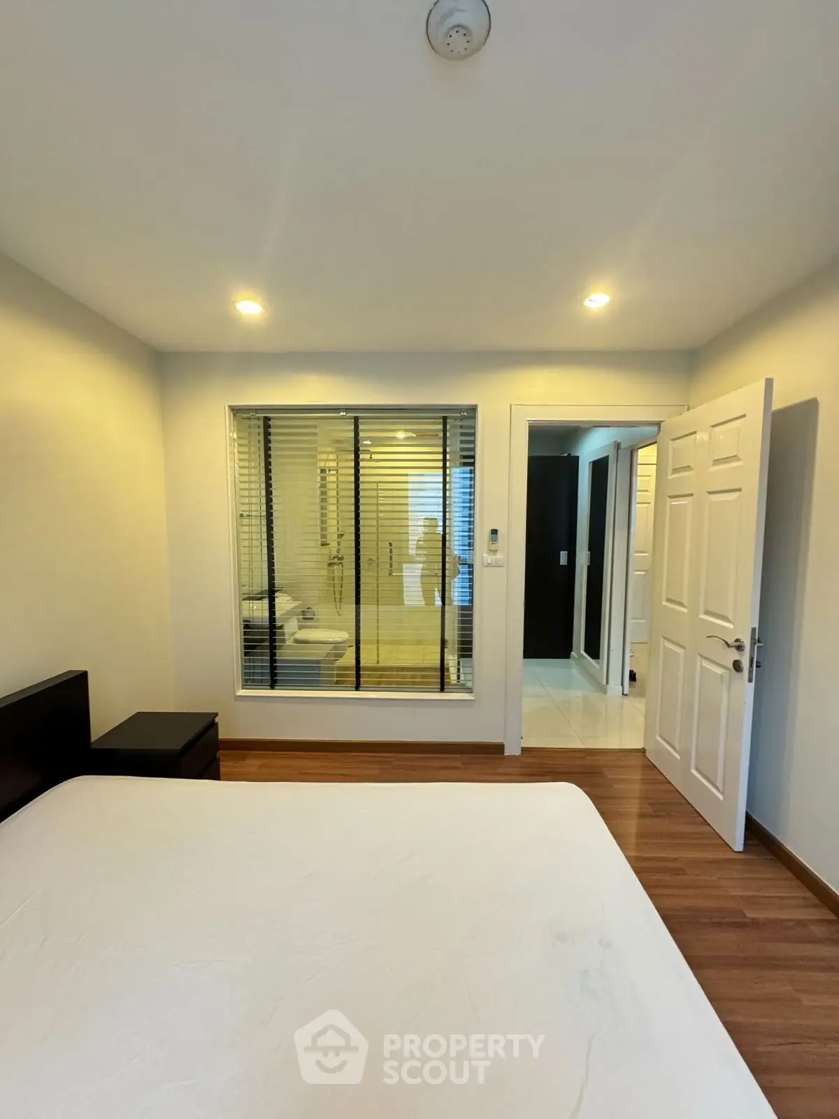 Modern bedroom with ensuite bathroom and wooden flooring