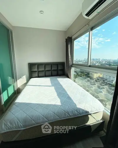 Bright bedroom with large window offering stunning city views, featuring a comfortable bed and modern decor.