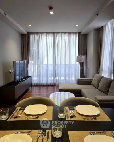Modern living room with elegant decor and large windows offering natural light