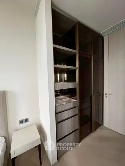 Modern bedroom with sleek built-in wardrobe and minimalist furniture design.