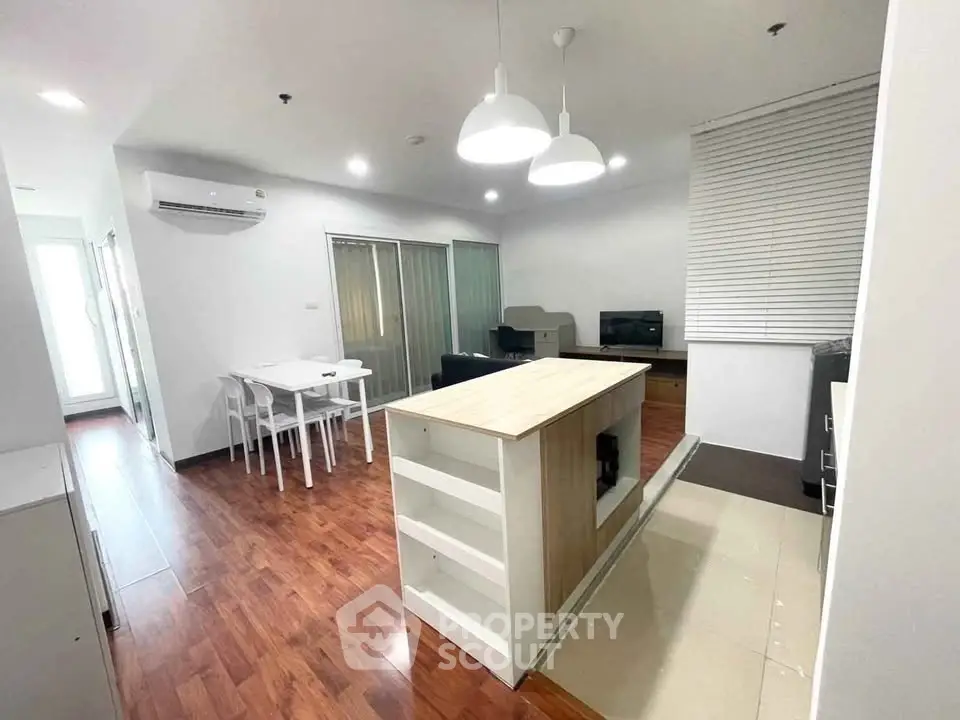 Modern open-plan living room with stylish dining area and contemporary lighting.