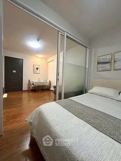 Cozy bedroom with sliding glass doors and elegant decor in modern apartment.