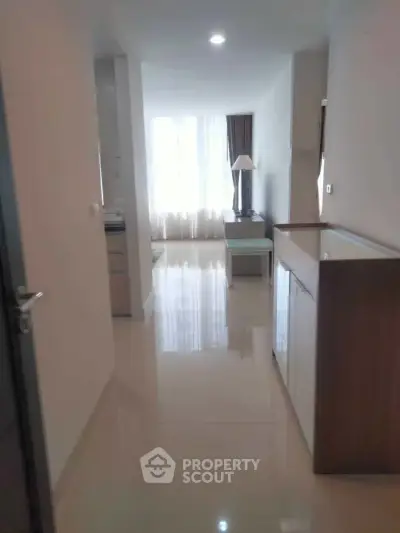 Spacious apartment hallway leading to a bright living area with modern decor.