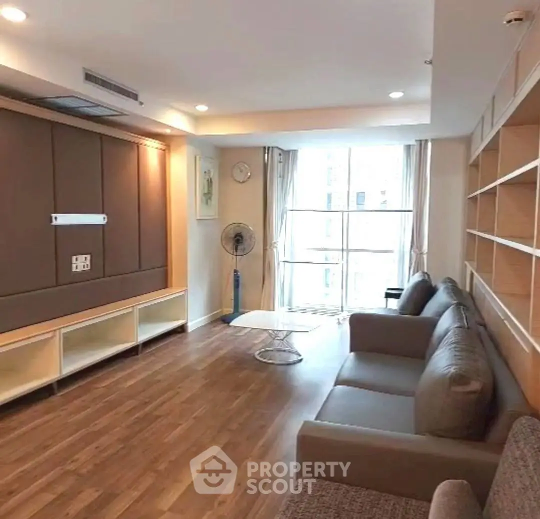 Spacious living room with modern furniture and large window for natural light.