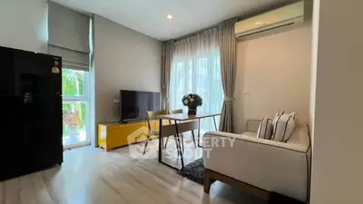 Modern living room with stylish decor, large windows, and cozy seating area.