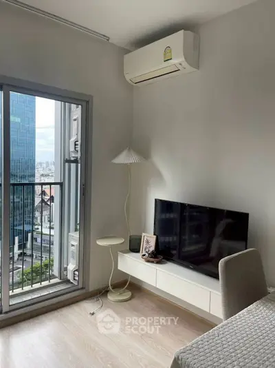 Modern living room with balcony view and sleek furniture in urban apartment.