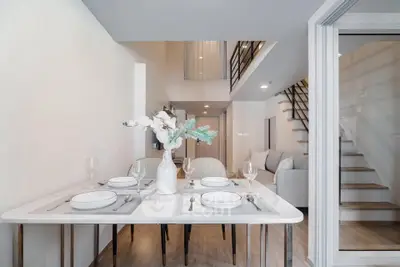 Modern duplex dining area with elegant table setting and stylish staircase