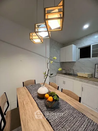 Modern kitchen with stylish lighting and wooden dining table