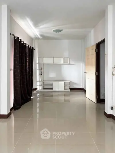 Spacious empty room with glossy tiled floor and modern shelving unit