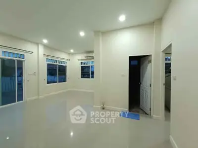 Spacious unfurnished living room with large windows and glossy floors