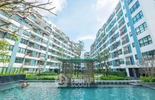 Modern apartment complex with pool and lush landscaping