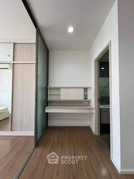 Modern study nook with sleek wooden flooring and built-in desk in a stylish apartment.