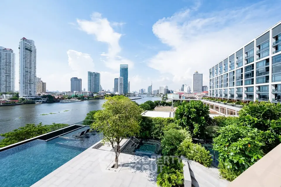 Stunning riverfront view from modern high-rise with lush greenery and infinity pool.