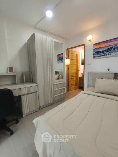 Cozy bedroom with modern furniture and warm lighting, perfect for relaxation.