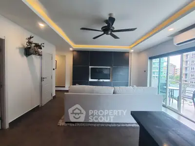 Modern living room with ceiling fan and balcony view in luxury apartment