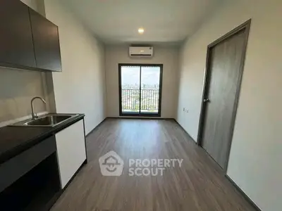 Modern minimalist kitchen with sleek cabinetry and large window offering city views.