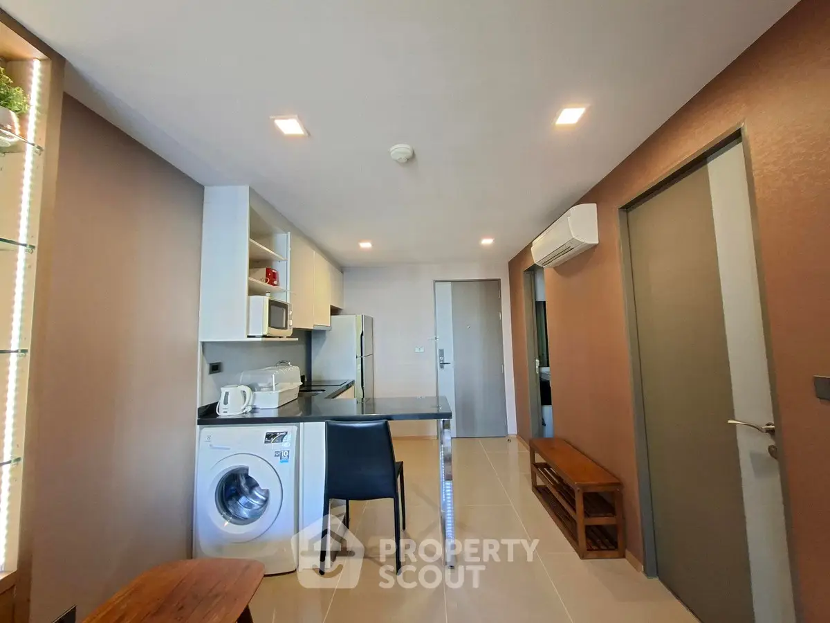 Modern kitchen with washing machine and sleek appliances in open layout
