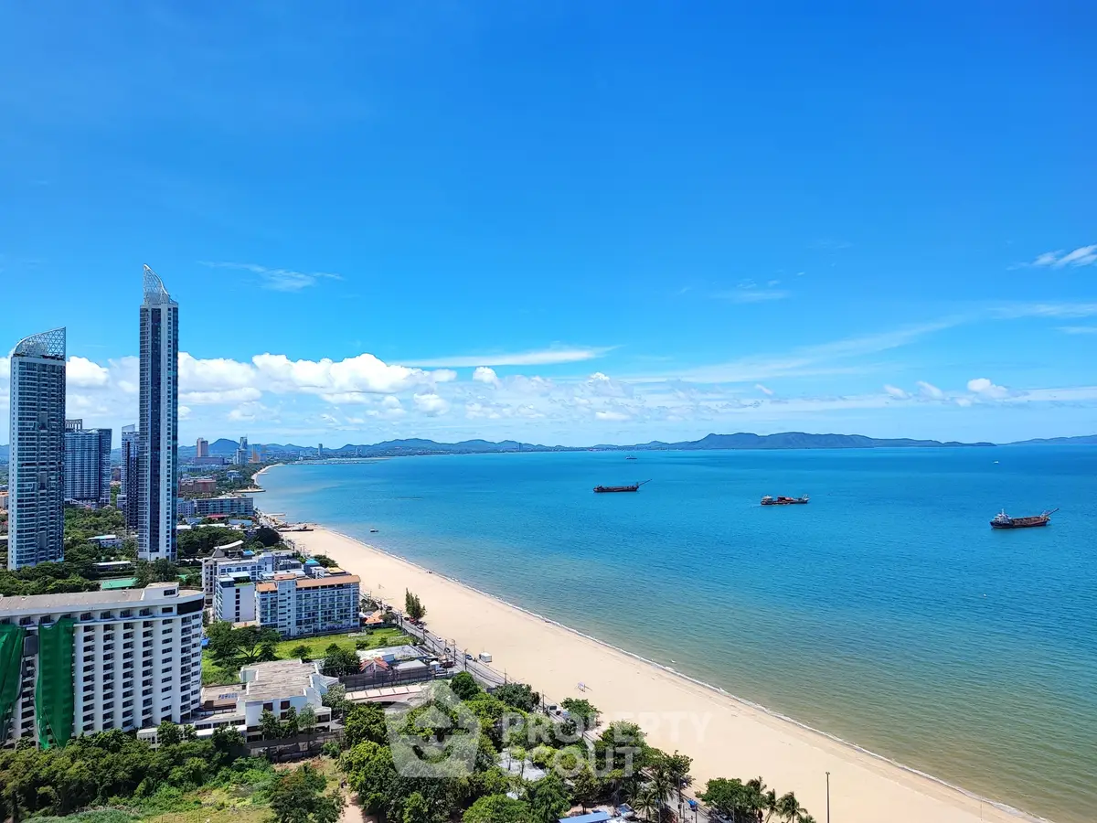 Stunning beachfront view with high-rise buildings and clear blue skies, perfect for luxury real estate.