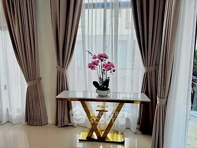 Elegant living room corner with stylish curtains and decorative table.