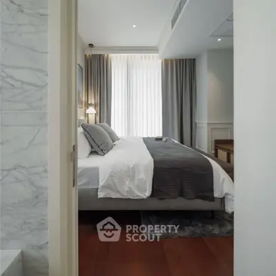 Elegant bedroom with modern decor and natural light, featuring a cozy bed and stylish curtains.