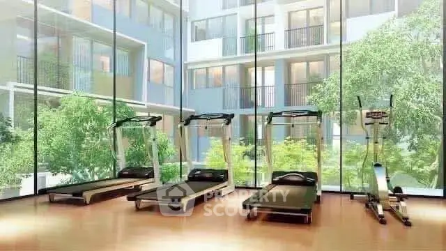 Modern gym with treadmills and large windows overlooking lush greenery in luxury apartment complex.