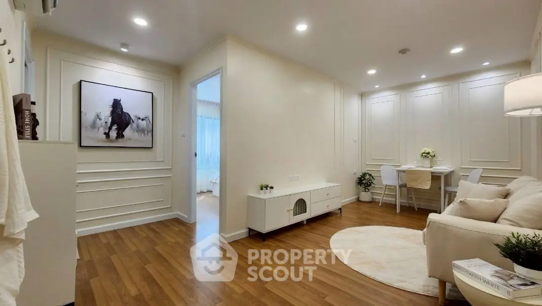 Elegant living room with wooden flooring, cozy seating, and stylish decor