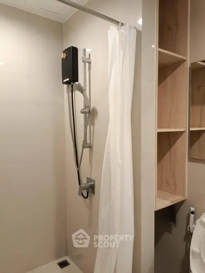Modern bathroom with shower and curtain, featuring sleek storage shelves.