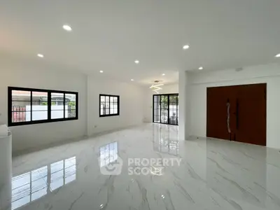 Spacious modern living room with glossy white flooring and large windows