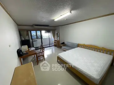 Spacious bedroom with balcony in modern apartment, featuring a large bed and stylish furniture.
