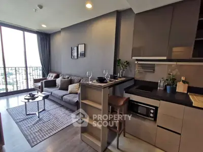 Modern open-layout living room with kitchen, featuring sleek design and large windows for natural light.