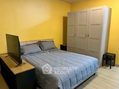 Cozy bedroom with modern furniture and vibrant yellow walls, perfect for relaxation.