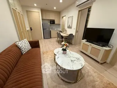 Modern living room with stylish furniture and open kitchen layout in a cozy apartment.