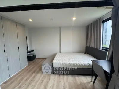 Modern bedroom with large windows and sleek furniture in a stylish apartment.