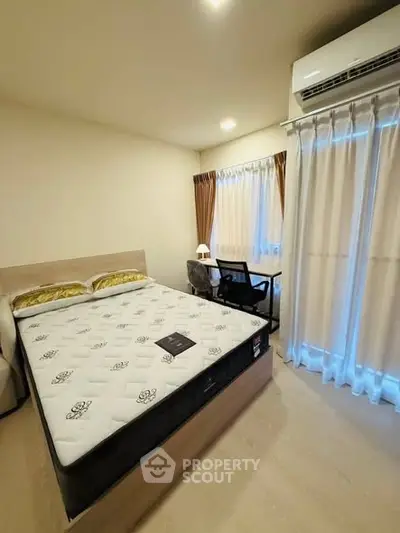 Cozy bedroom with modern furnishings and natural light, featuring a comfortable bed and a work desk by the window.