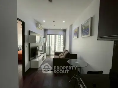 Modern living room with sleek furniture and large window offering city view