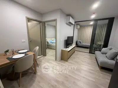 Modern apartment interior with open living and dining area, featuring stylish furniture and neutral tones.