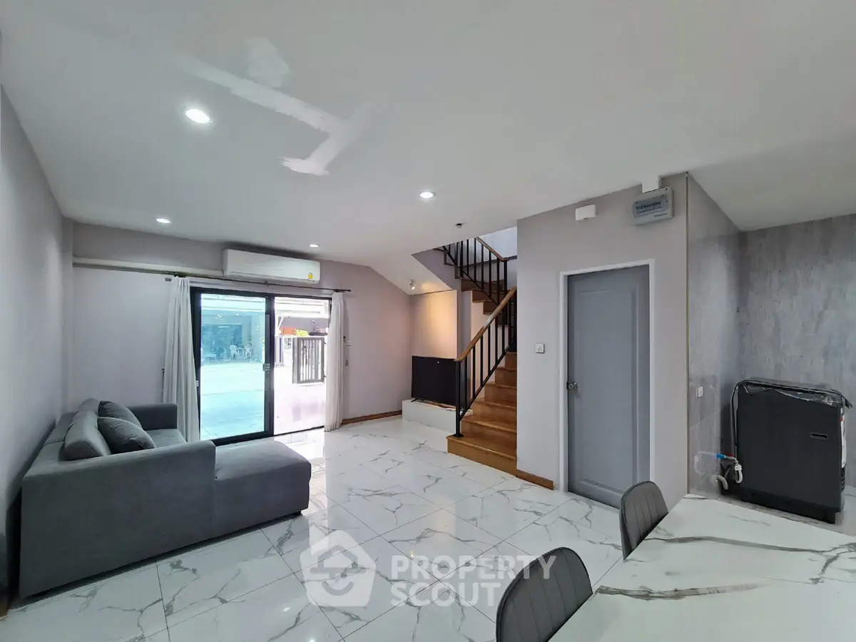 Spacious modern living room with marble flooring and staircase