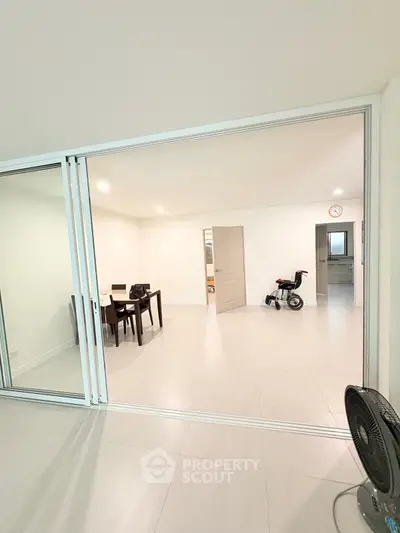 Spacious modern living area with sliding glass doors and minimalist decor