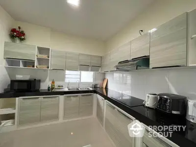 Modern kitchen with sleek cabinetry and black countertops in a contemporary home.