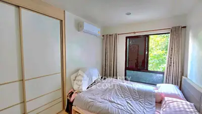 Cozy bedroom with large window and air conditioning, featuring a comfortable bed and ample natural light.