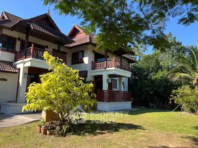 Charming two-story house with lush garden and traditional architecture, perfect for serene living.