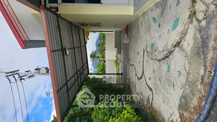 Charming exterior view of a cozy home with a covered driveway and lush greenery.